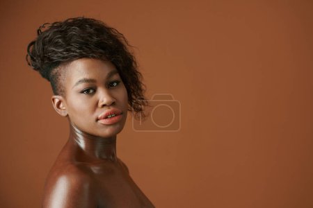 Téléchargez les photos : Portrait studio de jeune femme noire sérieuse avec coiffure moderne regardant la caméra - en image libre de droit
