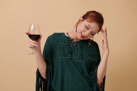 Photo for Young transgender woman relaxing with glass of red wine - Royalty Free Image