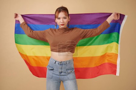 Foto de Mujer transgénero joven sosteniendo la bandera del mes orgullo - Imagen libre de derechos