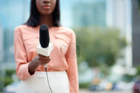 Téléchargez les photos : Image recadrée d'un journaliste tenant un microphone lorsqu'il parle à des témoins oculaires - en image libre de droit