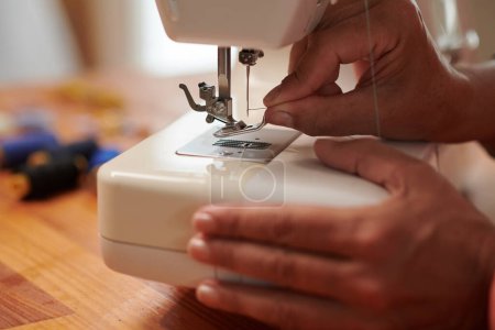 Foto de Imagen de cerca de costurera roscando aguja de la máquina de coser - Imagen libre de derechos