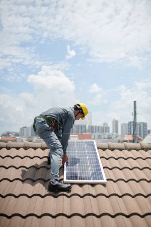 Foto de Constructor instalando panel solar en el techo del cliente - Imagen libre de derechos