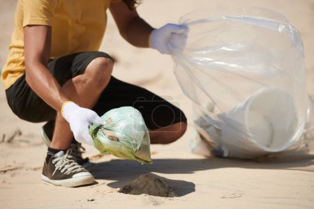 Téléchargez les photos : Collecte volontaire des ordures laissées par les touristes sur la plage de sable - en image libre de droit