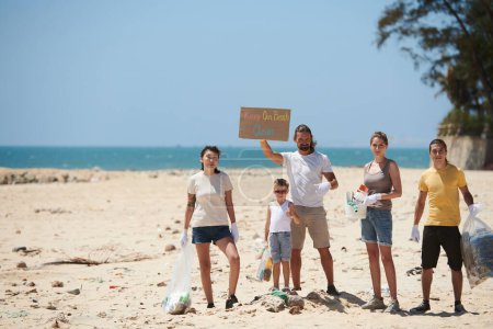 Photo for Group of activists picking up garbage on beach and asking society to keep beach clean - Royalty Free Image