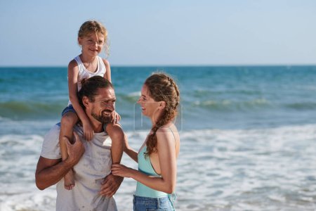 Photo for Happy family of three spending sunny day on beach - Royalty Free Image