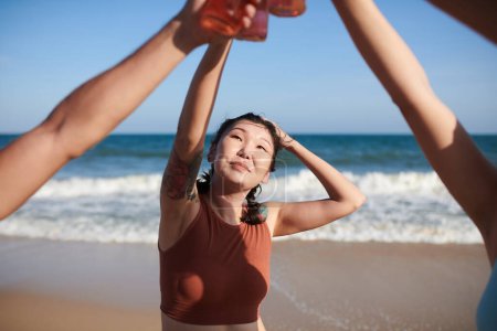 Foto de Mujer joven tomando bebidas con amigos en la playa - Imagen libre de derechos
