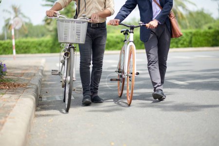 Téléchargez les photos : Image recadrée d'entrepreneurs avec des vélos marchant jusqu'au bureau le matin - en image libre de droit