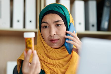 Foto de Empresaria musulmana estresada llamando a su terapeuta para discutir nueva medicina prescrita - Imagen libre de derechos