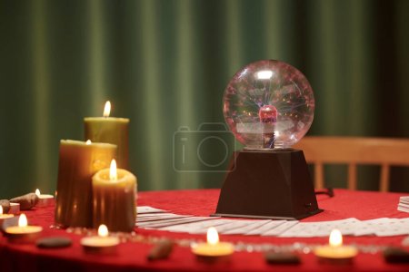 Téléchargez les photos : Boule de cristal et bougies allumées sur la table du voyant - en image libre de droit