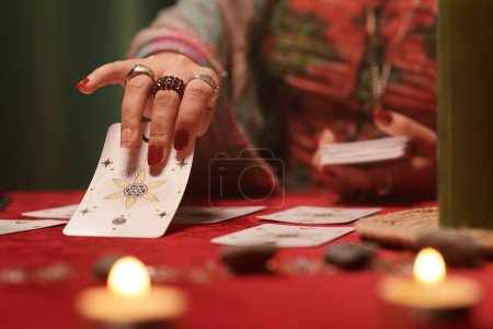 Foto de Imagen de primer plano de adivino extendiendo cartas del tarot tratando de ver el futuro - Imagen libre de derechos
