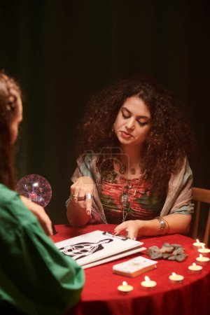 Photo for Healer talking to client, explaining every detail in chakra chart - Royalty Free Image