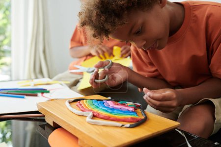 Photo for Creative kid making rainbow out of moulding clay - Royalty Free Image