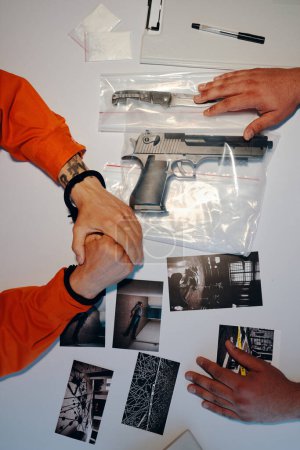 Photo for Hands of detective showing criminal photos of crime scene and murder weapon - Royalty Free Image