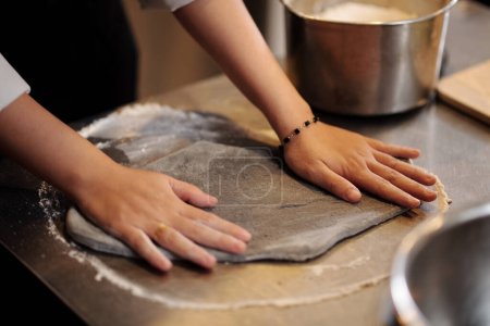 Photo for Hands of pizza maker kneading and shaping dough - Royalty Free Image