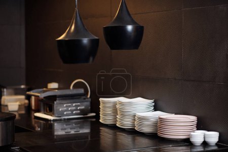 Photo for Stacked plates on counter in modern kitchen of restaurant - Royalty Free Image