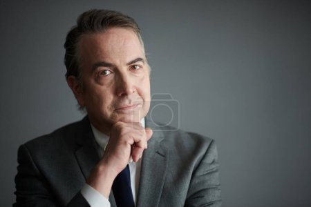 Photo for Portrait of positive pensive middle-aged entrepreneur looking at camera - Royalty Free Image