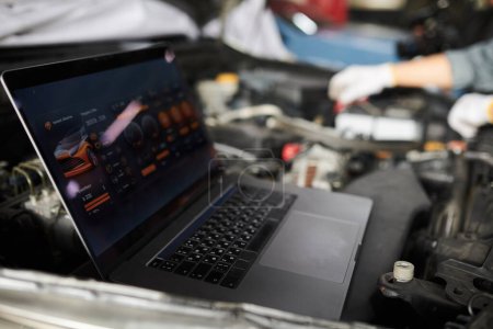 Photo for Mechanics using program on laptop when analyzing car computer systems and components - Royalty Free Image