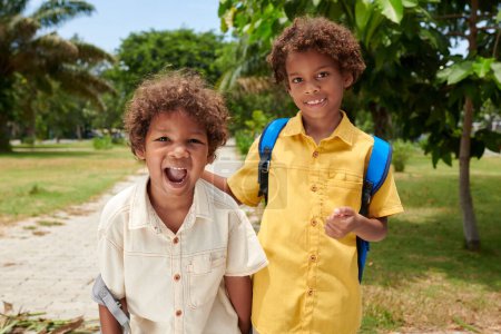 Téléchargez les photos : Portrait d'enfants joyeux passant du temps dans le parc de la ville après l'école - en image libre de droit