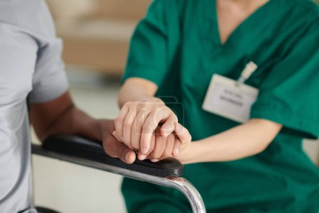 Téléchargez les photos : Aide-soignant touchant la main du patient pour exprimer son soutien - en image libre de droit