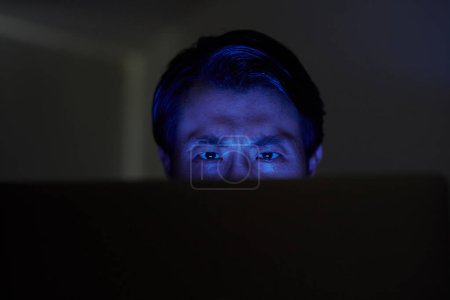 Foto de Fruncir el ceño hacker tratando de entrar en el sistema informático tarde en la noche - Imagen libre de derechos