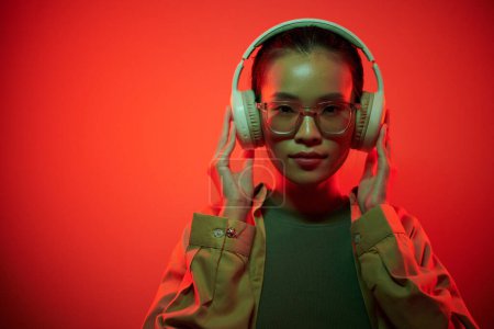 Téléchargez les photos : Portrait de jeune gamer femme portant des écouteurs lors de la préparation pour le raid - en image libre de droit