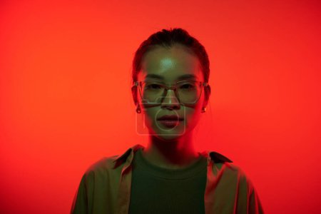 Photo for Portrait of serious young hacker standing in red light and looking at camera - Royalty Free Image