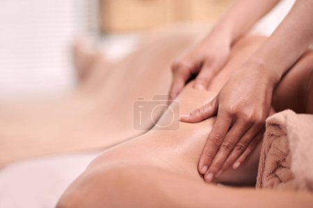 Foto de Enfoque en las manos de la fisioterapeuta femenina dando masaje de la parte superior del brazo y el hombro de joven cliente masculino de salón de spa profesional - Imagen libre de derechos