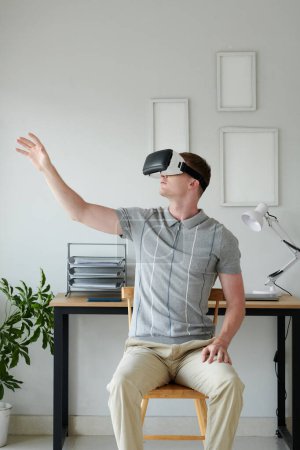 Foto de Desarrollador en pruebas de auriculares nueva aplicación de realidad virtual en casa - Imagen libre de derechos