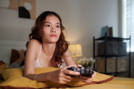 Foto de Joven mujer pasando tiempo sola jugando videgames - Imagen libre de derechos