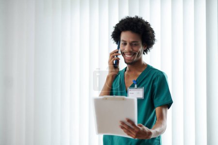 Téléchargez les photos : Infirmière médicale souriante appelant le patient pour lui communiquer les résultats des tests médicaux - en image libre de droit