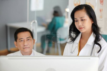 Téléchargez les photos : Équipe de médecins regardant l'écran d'ordinateur avec l'image de rayon X - en image libre de droit
