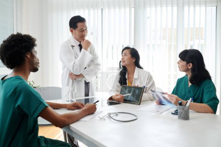 Photo for Group of medical workers gathered to discuss difficult case - Royalty Free Image