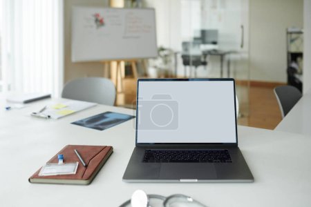 Photo for Opened laptop with empty screen and planner of desk of general practitioner - Royalty Free Image