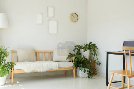 Photo for Light apartment interior with comfy couch and lush plants - Royalty Free Image