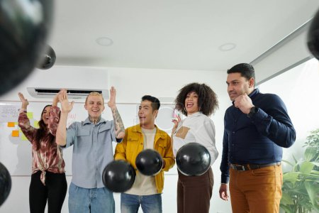 Photo for Team of developers celebrating successful startup launch - Royalty Free Image