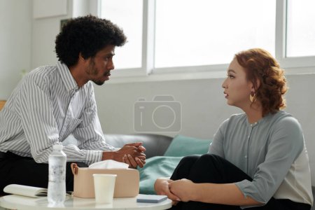 Foto de Psicoterapeuta serio hablando con su paciente que sufre de ansiedad y ataques de pánico - Imagen libre de derechos