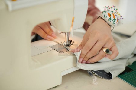 Téléchargez les photos : Image rapprochée de la femme créative utilisant une machine à coudre lors de la confection de la robe - en image libre de droit