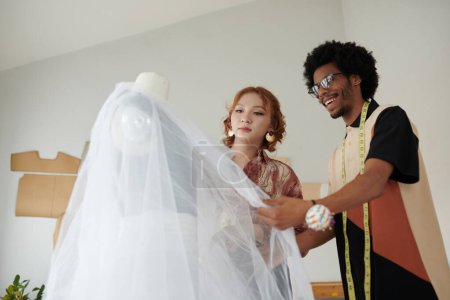 Foto de Emocionados diseñadores de moda creando hermoso vestido de novia - Imagen libre de derechos