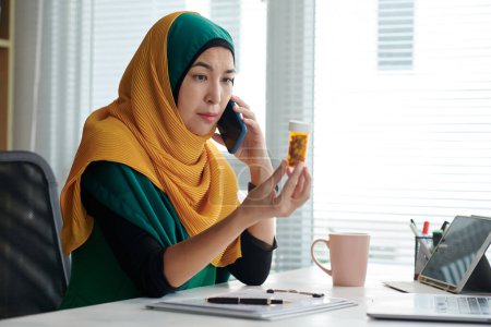 Téléchargez les photos : Portrait d'une gestionnaire de projet musulmane mature qui appelle son médecin pour discuter de l'effet du nouvel antidépresseur - en image libre de droit