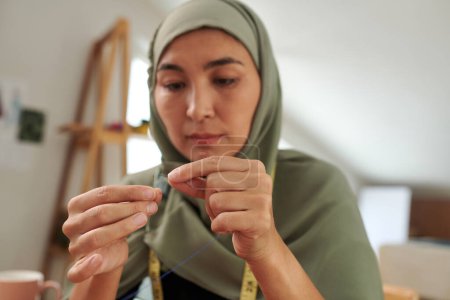 Foto de Mujer musulmana en hijab hilo aguja, grasa y hobbie concepto - Imagen libre de derechos