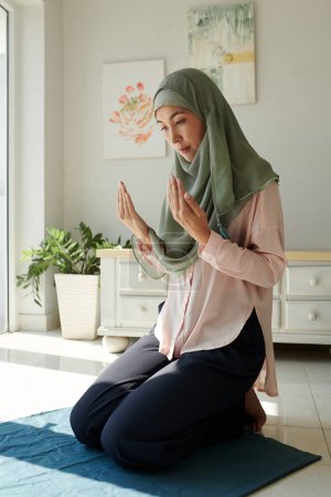 Foto de Mujer musulmana en hiyab rezando en casa, concepto de fe y espiritualidad - Imagen libre de derechos