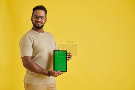 Photo for Excited software developer showing digital tablet with green screen - Royalty Free Image