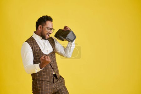 Photo for Excited man singing and dancing to music in speaker - Royalty Free Image
