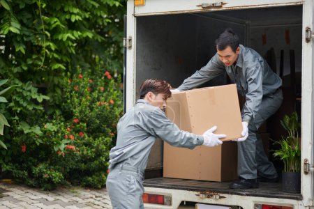 Photo for Movers loading big heavy boxes in van - Royalty Free Image