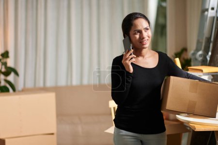 Photo for Woman calling to manager of moving company when packing belongings - Royalty Free Image