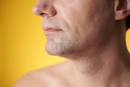Téléchargez les photos : Image recadrée d'un homme d'âge moyen à la peau claire et rasée, isolé sur du jaune - en image libre de droit