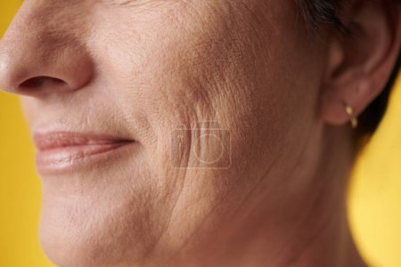 Téléchargez les photos : Image rapprochée d'une femme mûre souriante à la peau propre et douce - en image libre de droit