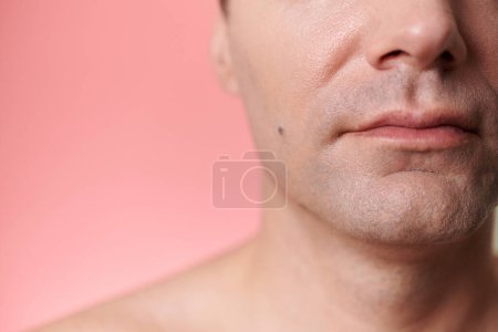 Téléchargez les photos : Image recadrée d'un homme mûr sans sourire posant sur fond rose - en image libre de droit