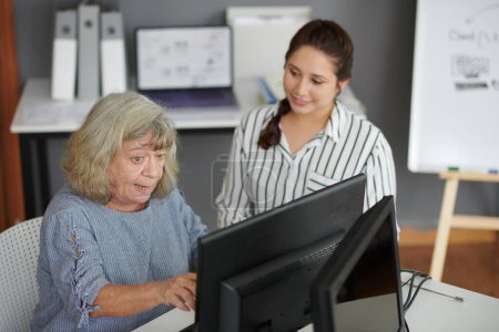 Photo for Aged woman learning how to send e-mails on computer - Royalty Free Image