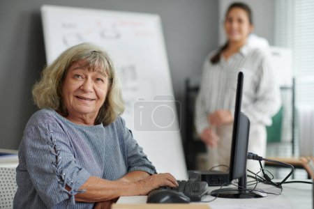 Téléchargez les photos : Portrait d'une femme âgée souriante assistant à un cours de formation en informatique - en image libre de droit